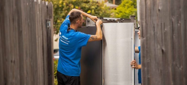 Rockstar mover dismantling the fridge outside 