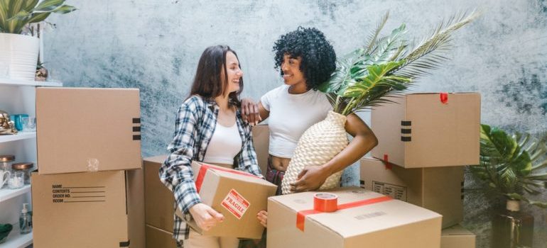 two girls surrounded by moving boxes 