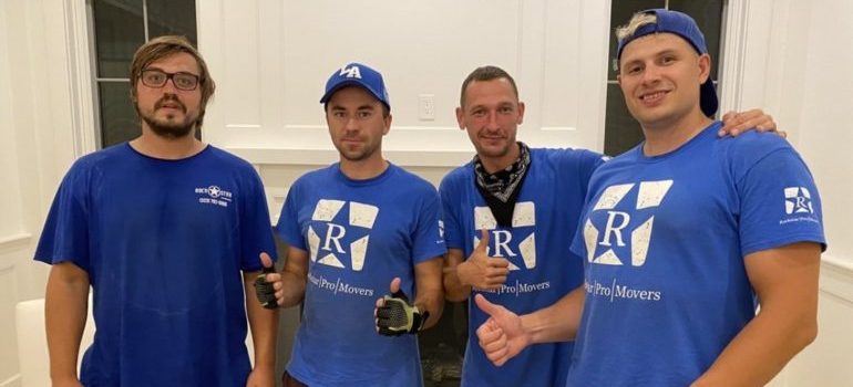 4 movers with a smile standing indoors