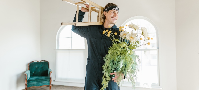 mover holding chair and flowers