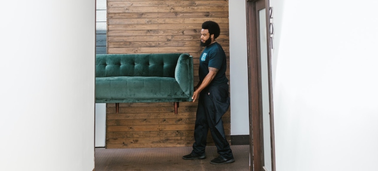 A man carrying a sofa