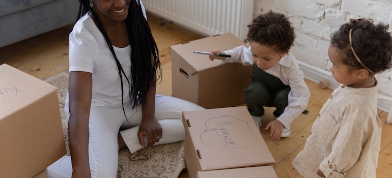 A mom with two kids labeling boxes while thinking about Las Vegas to Dallas–Fort Worth metroplex move made simple;