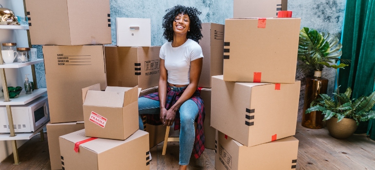 woman surrounded with packing boxes as an example of materials you should be using if you want to pack large furniture for your move from Austin