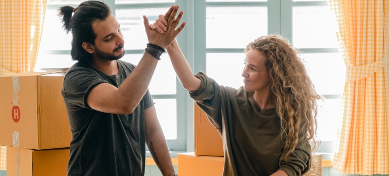 A couple high five after choosing the cheapest time for your family relocation in TX