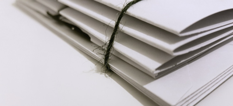 four different white files with documentation in them on a white table