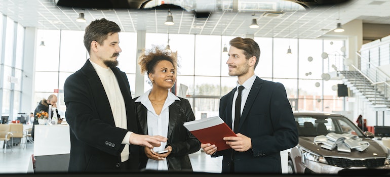 Car salesman talking to a couple