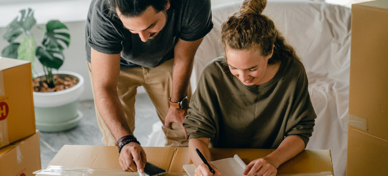 Man and woman consulting moving across LA checklist and packing for the move