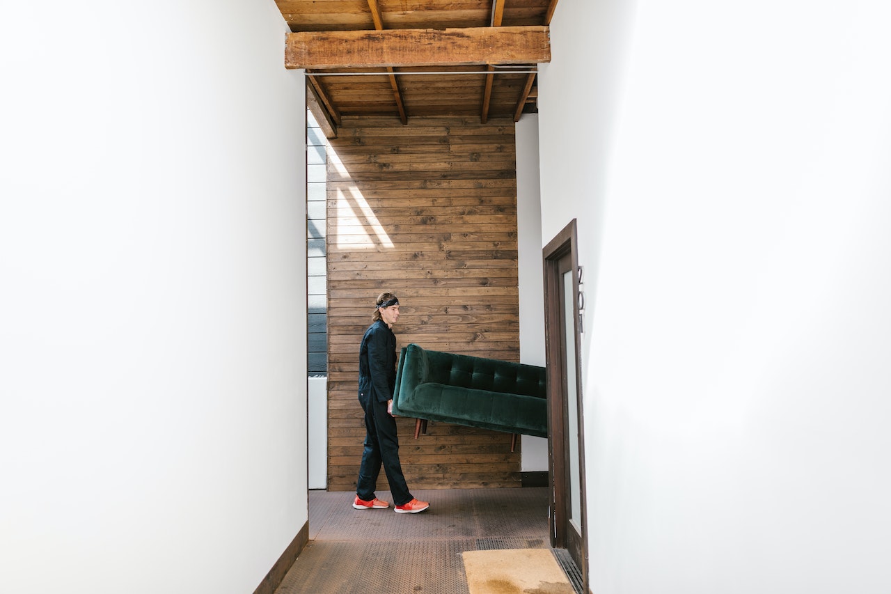 Man carriying a green sofa