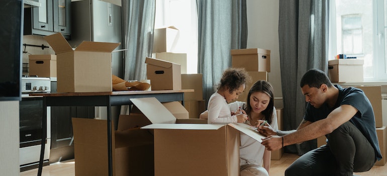 a family of three unpacking their moving boxes about to unleash creative ideas for leftover moving boxes